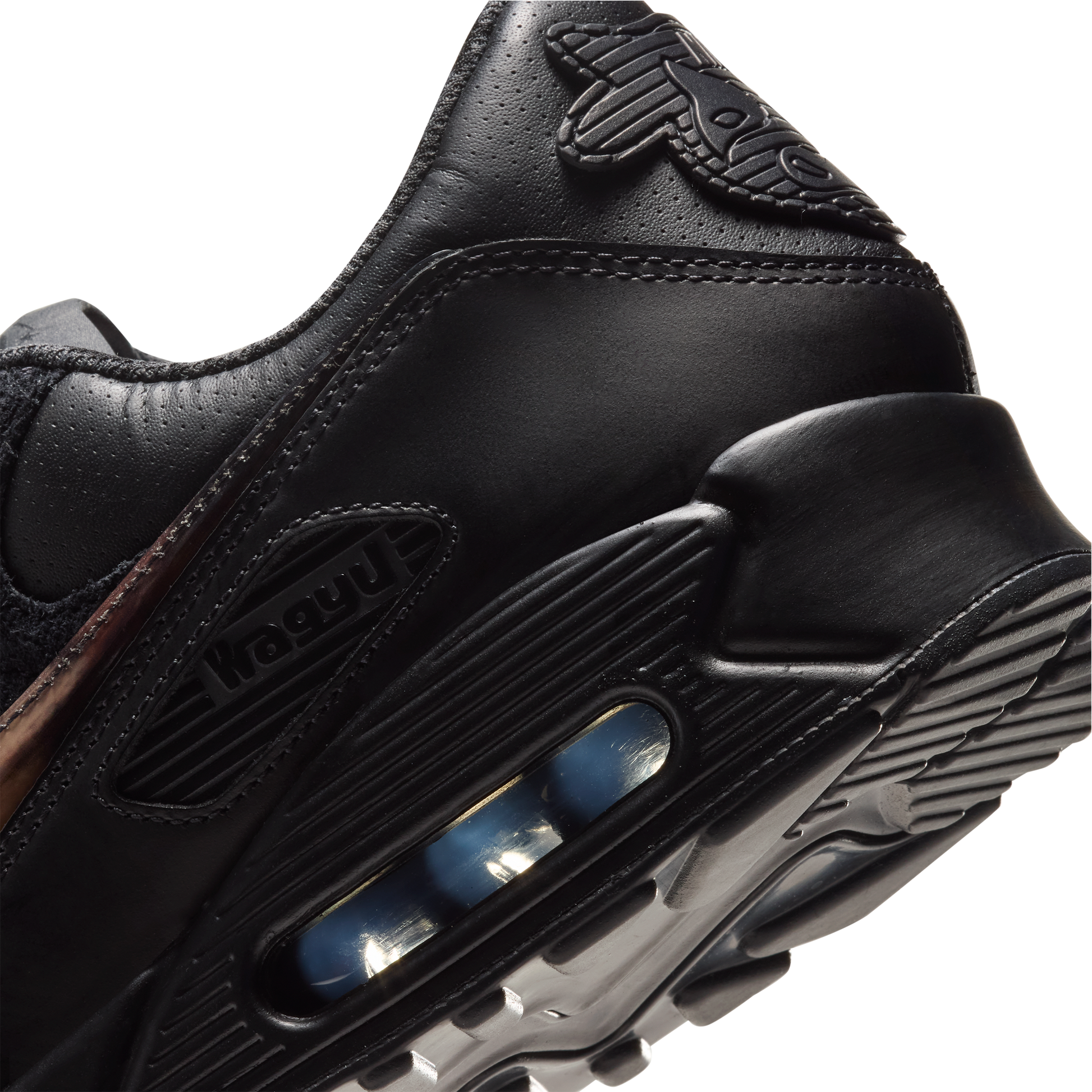 Close-up of a black leather sneaker showing the heel and midsole with a visible air cushion unit, on a plain white background. SIgned Wagyu