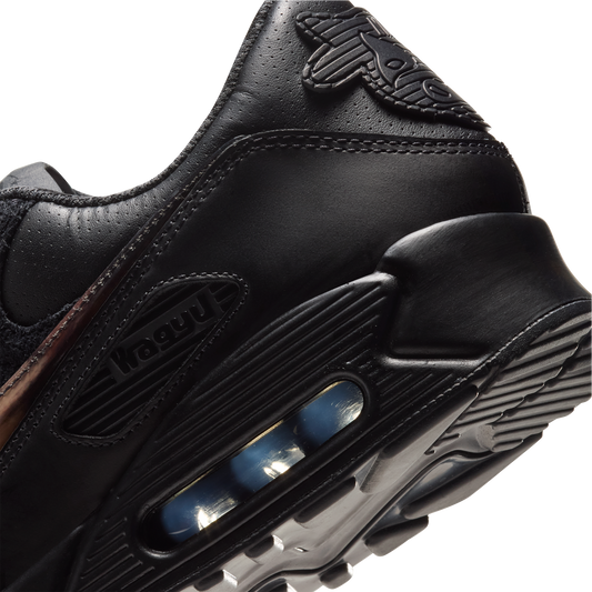 Close-up of a black leather sneaker showing the heel and midsole with a visible air cushion unit, on a plain white background. SIgned Wagyu